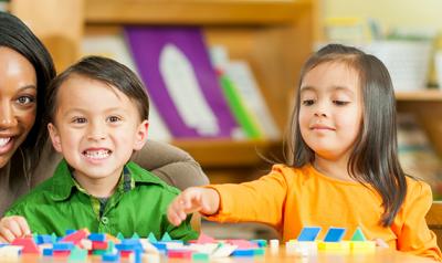 Teacher and children playing with blocks.